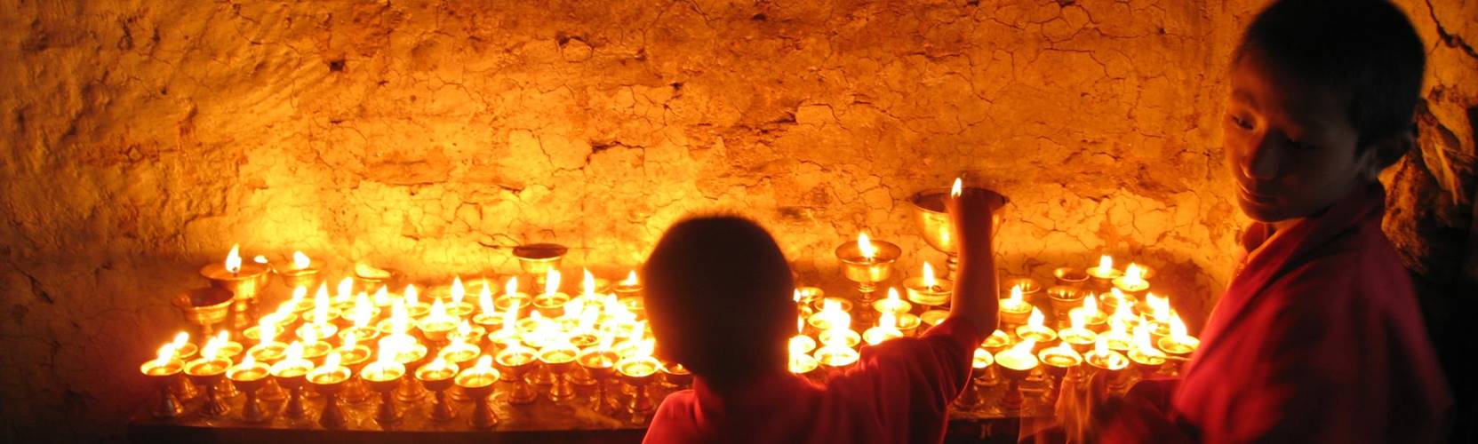 Student buddhist monks light butter lamps in a monastery in Solu Khumbu Nepal